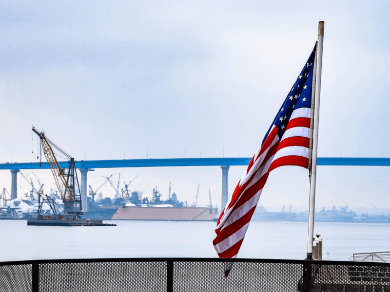 An American flag flying on a ferry overlooking a river