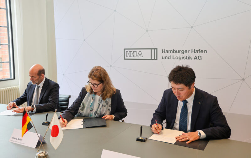 Three people signing contracts